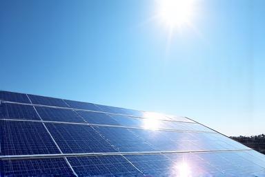 Clean, reflective solar panels on a rooftop with a clear sky